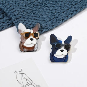 Detailed view of acrylic French Bulldog brooches with marble patterns and sunglasses