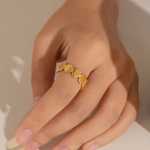 Detail of gold hollow star ring with crystals worn on finger in natural soft lighting