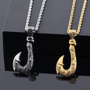 Detailed view of silver and gold fish hook pendants with twisted rope chains and reflections