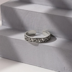 Detailed relief of celestial sun and moon patterns on a vintage silver open ring
