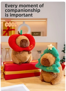 Capybara plush toys with Christmas tree and apple collars in festive home setting