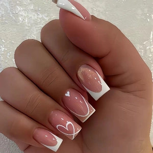 White French tip press-on nails with heart patterns on pink long square nails