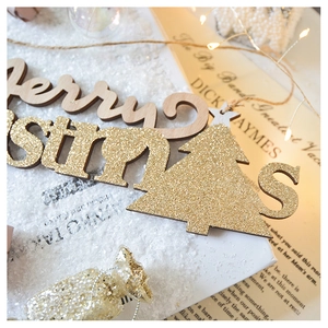 Detail of wooden Merry Christmas tree ornament with golden glitter finish and vintage decor