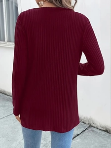 Macro detail of the dark red ribbed knit texture on the back of this elegant jacket