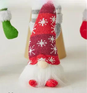 Close-up of red knit Christmas gnome hat with snowflake pattern and white plush beard
