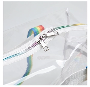 Macro shot of dual metal zippers and rainbow straps on a clear PVC beach tote bag