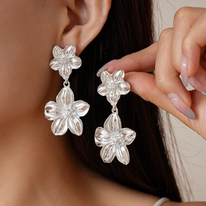 Silver flower drop earrings for women with double-layered metallic petals shown on model