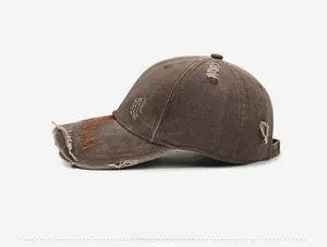 Close-up of distressed dark brown canvas baseball cap with PALM embroidery and torn details