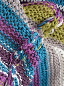 Makro-Detail von gestreiftem Strickstoff mit blauen, lila, grauen und weißen Garnen