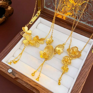Detailed macro view of gold-plated flower tassel necklaces in a wooden jewelry box