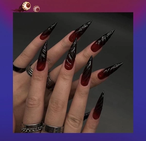 Detail of long stiletto press-on nails with black and red 3D gradient and texture
