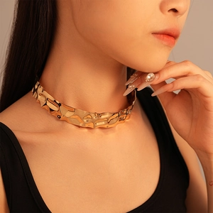 Detail of a wide gold choker with irregular liquid metal ripples and luxurious wavy texture