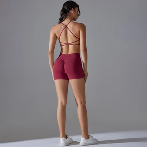 Detail of cross-back sports bra and high-waist shorts in dark red seamless elastic fabric
