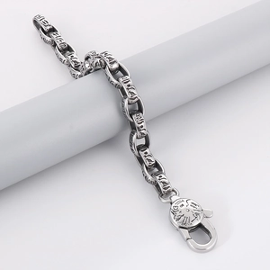 Detailed view of punk oval link bracelet with Pharaoh engravings and embossed lobster clasp