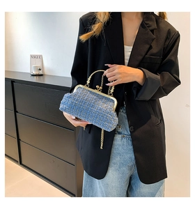 Fashionable blue tweed handbag with gold metal hardware and chain strap shown by model