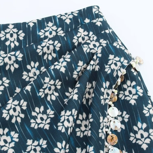 Deep teal printed skort with white floral patterns and shell bead charm details