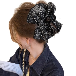 French retro black paisley print bow hair claw clip worn by a model on white background