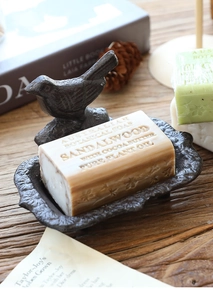 Vintage cast iron bird soap dish featuring decorative petal edges and sandalwood soap