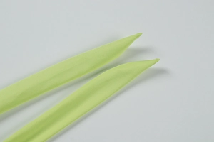 Detailed close-up of lime green fabric ties with fine stitching on a sleek dress
