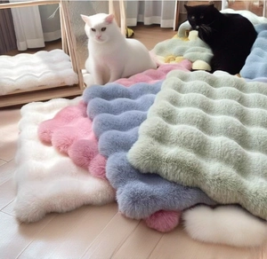 Detailed view of wavy plush pet mats in white, pink, blue and green soft faux rabbit fur
