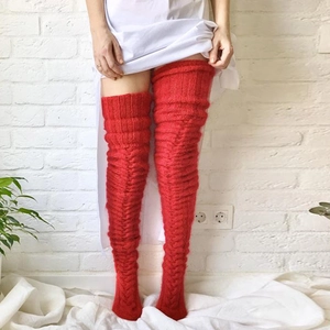 Detailed knit texture of red over-the-knee wool socks with stylish cable pattern