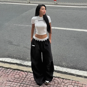 Détail du pantalon large avec bordure en dentelle blanche sur la taille noire contrastée