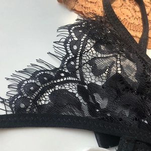 Close-up of black lace thong detail featuring delicate floral patterns and mesh texture