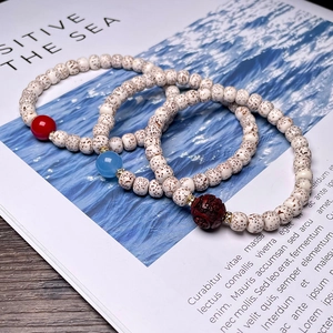 Star Moon Bodhi seed bracelet with red agate and aquamarine beads on a magazine