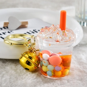 Detailed close-up of a creative milk tea keychain with floating pearls and golden bell