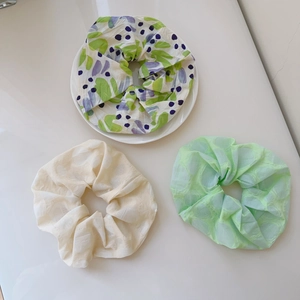 Detail of floral chiffon scrunchie set with mint green and cream jacquard textures