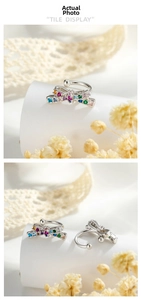 Détail d'un ear cuff nœud coloré serti de zircons multicolores sur support blanc