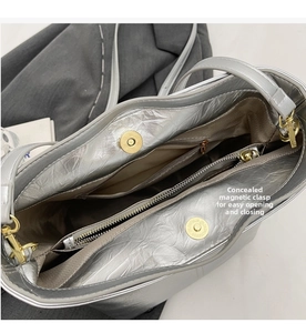 Detailed interior of the silver bucket bag showing invisible magnetic buckles and compartments