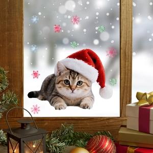 Close-up of a Christmas cat window sticker with snowflakes on a cozy wooden window frame