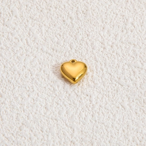 Macro detail of 18k gold plated 3D heart shaped charm pendant with a circular hanging hole