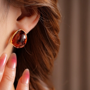 Macro view of vintage resin amber drop earring with polished gold metal edge
