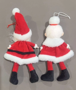 Detail view of the back of two Christmas plush hangers showing Santa Claus felt dolls