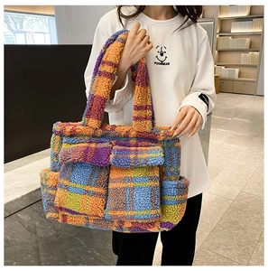Detail of colorful plaid faux shearling tote bag with two front pockets and soft texture