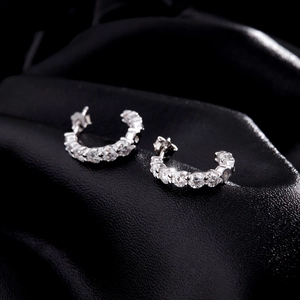 Boucles d'oreilles créoles C en argent s925 avec moissanite sur tissu noir soyeux