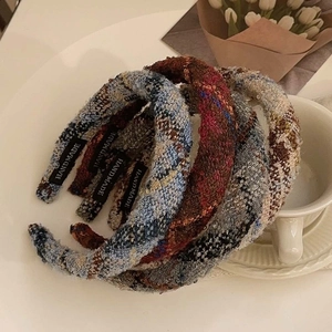 Elegant tweed padded headbands in four colors with handmade tags on a white surface