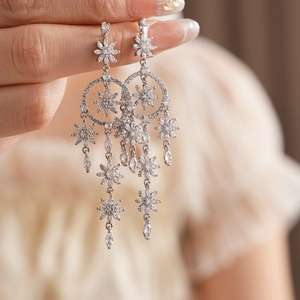 Macro shot of silver zircon flower tassel earrings worn for an elegant vintage look