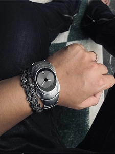 Detail of silver Y2K asymmetrical watch with dark grey dial on wrist with bracelet