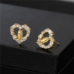 Gold heart earrings with Virgin Mary relief and sparkling clear stones on black texture