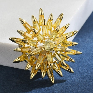 Macro view of gold sunburst brooch featuring radiant yellow multifaceted gemstones