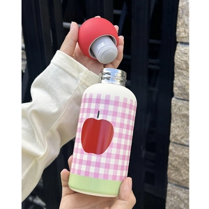 Detail of hand opening red lid on a pink checkered stainless steel 350ml water bottle