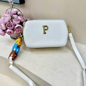 Detail view of a white crossbody bag with gold P logo and colorful chain strap