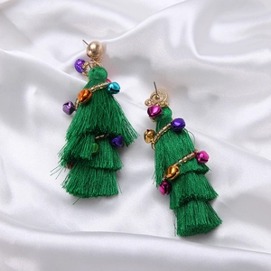 Detail of Christmas tree tassel earrings with multi-colored bells on white silk background