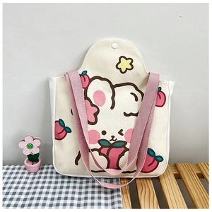 Detail of canvas tote featuring cute rabbit and peach print with pink shoulder straps