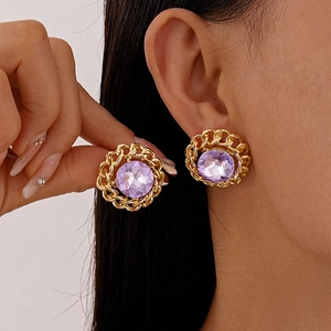 Vintage gold chain-link earrings with purple crystal center on model for elegant style