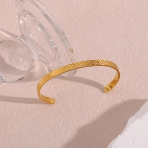 Macro detail of 18K gold plated stainless steel bracelet with hammered metal texture