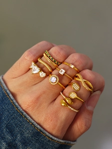 Macro shot of gold-plated rings with heart-shaped zircon and unique spoon design